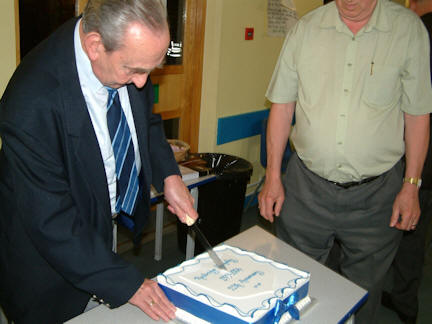 Alf cuts the celebration cake